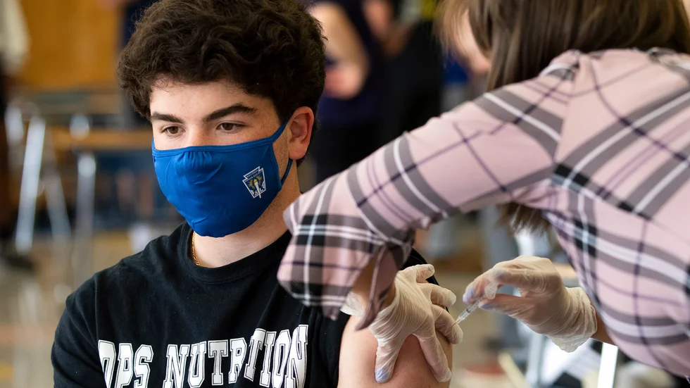 Gymnasieeleven AJ Tomassoni får en vaccinspruta mot covid-19 på Valley View High School i Archbald, i delstaten Pennsylvania, den 30 april.
