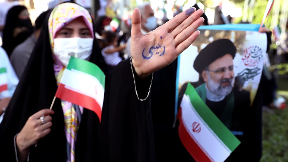 En anhängare till den konservative presidentkandidaten Ebrahim Raisi på ett valmöte i Teheran. På hennes hand står det just "Raisi".