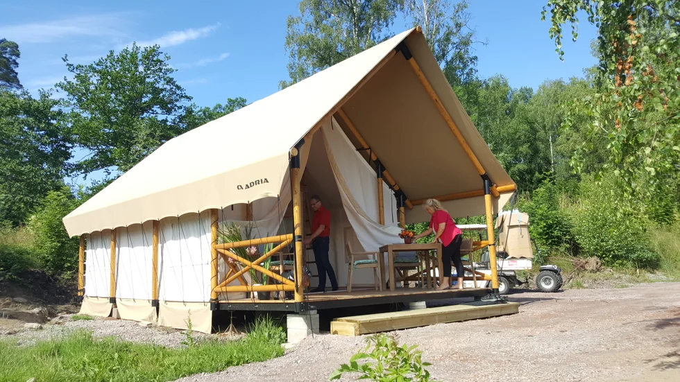Michael Carlsson och Pernilla Eriksson håller på att fixa det allra sista i glampingtältet. Snart ska även gräs rullas ut.