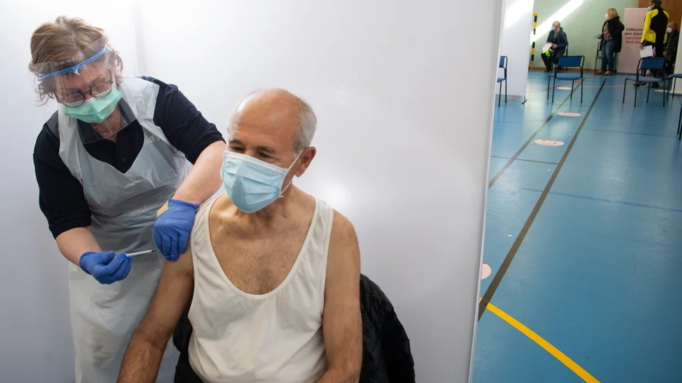 Sjuksköterskan Lotta Häller vaccinerar 63årige Mahmoud med Pfizer-Biontechs vaccin mot covid-19 i en gymnastiksal i Rinkeby i april.