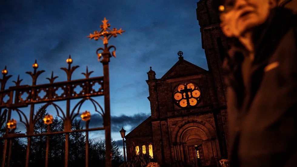 En fotgängare passerar en katolsk kyrka i nordirländska Aughnacloy. Arkivbild.