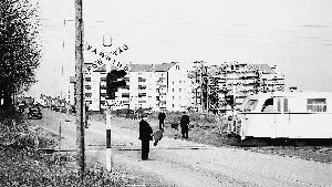 Hagebys gränsland in mot stan bestod av smalspårsjärnvägen Norrköping-Finspång-Örebro. Här passerar en rälsbuss försiktigt över Söderköpingsvägen (nuvarande Hagebygatan). Flaggvakter varnar landsvägsresenärer när tågsignalen är ur bruk. I bakgrunden syns sista stjärnhuset i raden utmed Söderköpingsvägen byggas. Så såg det ut i mitten på 1950-talet. Foto: Carl Werngren (Stadsmuseets samlingar)
