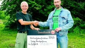 Bo Tufvesson, tar emot checken på 30 450 kronor från Per Thyselius.Foto: Johan Gustafsson