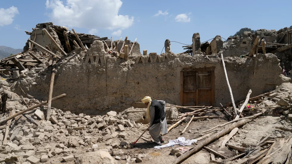 En man i provinsen Paktika röjer upp efter jordbävningen.