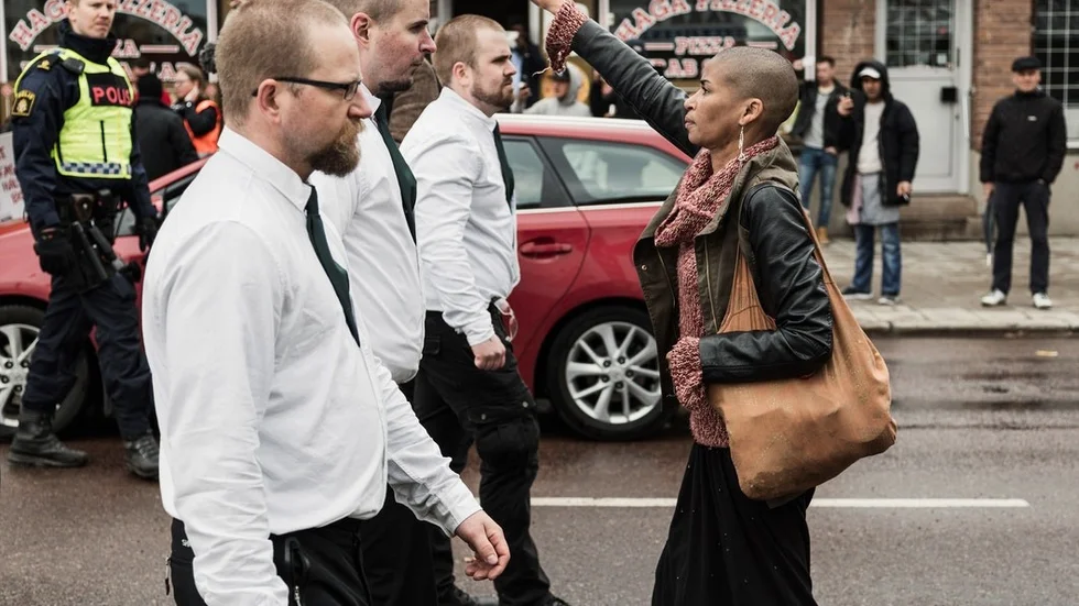 Årets bild 2017. En ensam kvinna, Tess Asplund, ställer sig med höjd näve mitt emot de uniformerade demonstranterna i en nazistdemonstration i Borlänge.