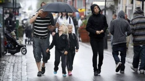 Morfar Jan Bergstedt från Svensbyn var en av många Pitebor som höll stadigt i paraplyet under måndagsdygnet, här med barnbarnen Tova, 6 (till vänster) och Saga, 7 under regnskyddet.