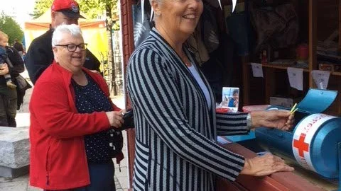 Anders Nilsson, Karin Nilsson och Inger Anundby köper lotter av Gammelstads Rödakors krets vid matmarknaden i Luleå.