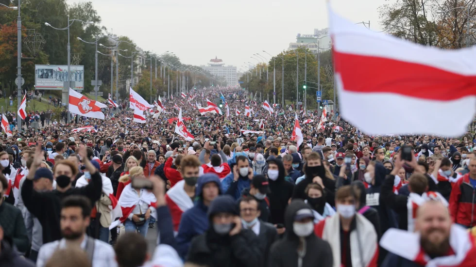 Demonstranter i Minsk viftar med en alternativ belarusisk flagga som ska symbolisera ett demokratiskt Belarus. Hundratusentals människor demonstrerade i Belarus 2020, men regimen slog ned missnöjet med rysk hjälp. Arkivbild.