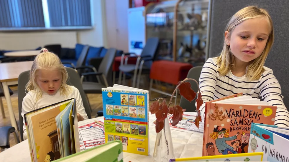 Julie Karlborg och Signe Christensen funderar vilken bok de ska läsa.