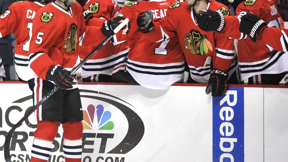 CORRECTS NAME OF TORONTO TEAM TO MAPLE LEAFS - Chicago Blackhawks' David Rundblad (5), of Sweden, celebrates with teammates on the bench during the first period of an NHL hockey game against the Toronto Maple Leafs in Chicago, Sunday, Dec. 21, 2014. (AP Photo/Paul Beaty)