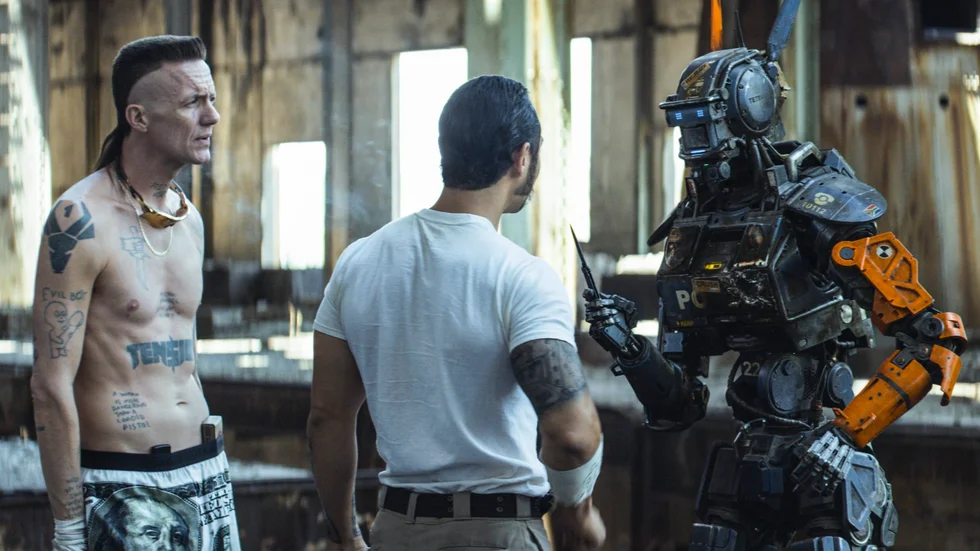 Konflikt. Ninja (Ninja) och Yankie (Jose Pablo Cantillo) försöker uppfostra Chappie (Sharlto Copley) till att bli en riktig gangster. Men han har fått lära sig av sin "skapare" Deon (Dev Patel) att det är fel att döda och stjäla. Foto: Columbia Pictures Foto: Courtesy of Columbia Pictures.