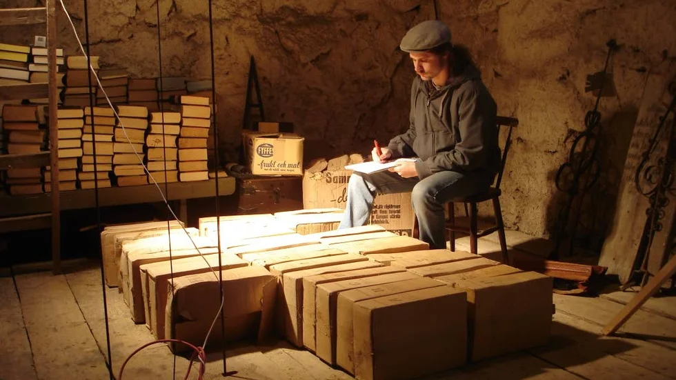 Arkivjobb. Albin Lindqvist under inventeringen 2008, här i Tryserums kyrktorn med arkivboxar om kristidsnämndens handlingar (de finns numera i Valdemarks kommunarkiv).
