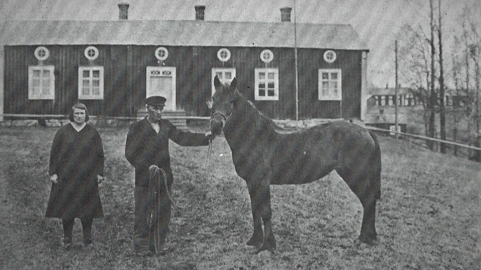 Framför den gamla Timmer-gården, numera bortriven, ses Timmer-Maria och Ernst Öhman.