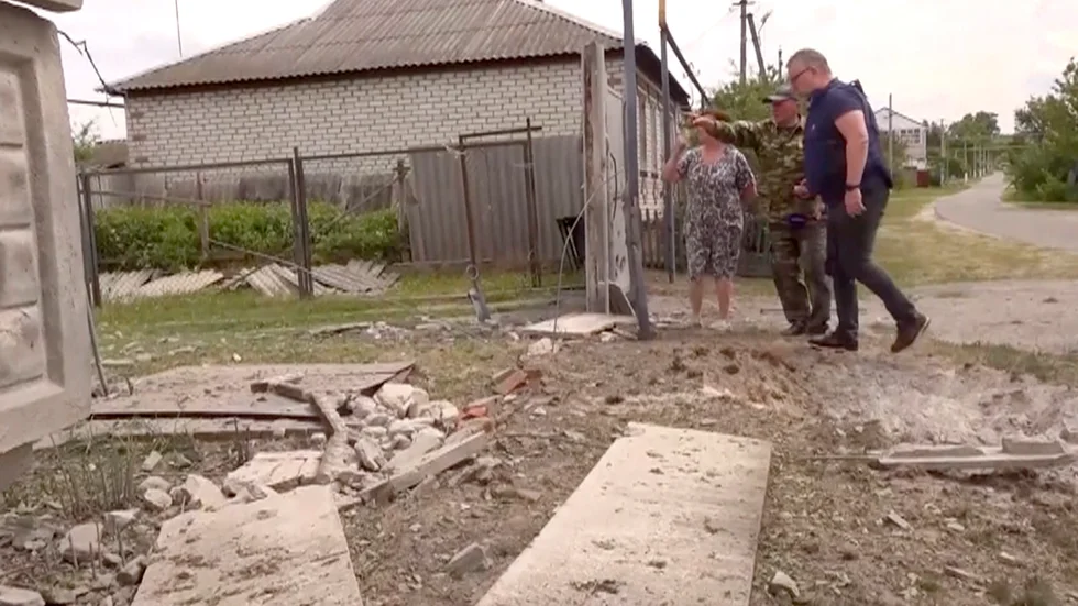 Människor i den ryska Belgorod-regionen ser över skadorna i ett delvis förstört bostadshus på tisdagen.