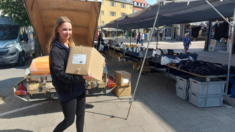 Matilda Johansson trivs med kundkontakterna och hälsar kunderna glatt välkomna men tycker det är slitigt att packa upp och ned vid varje marknad. Här hämtar hon en kartong med varor.