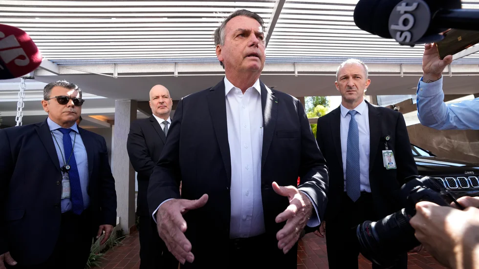 Brasiliens expresident Jair Bolsonaro talar till journalister efter att hans bostad genomsökts av den federala polisen.