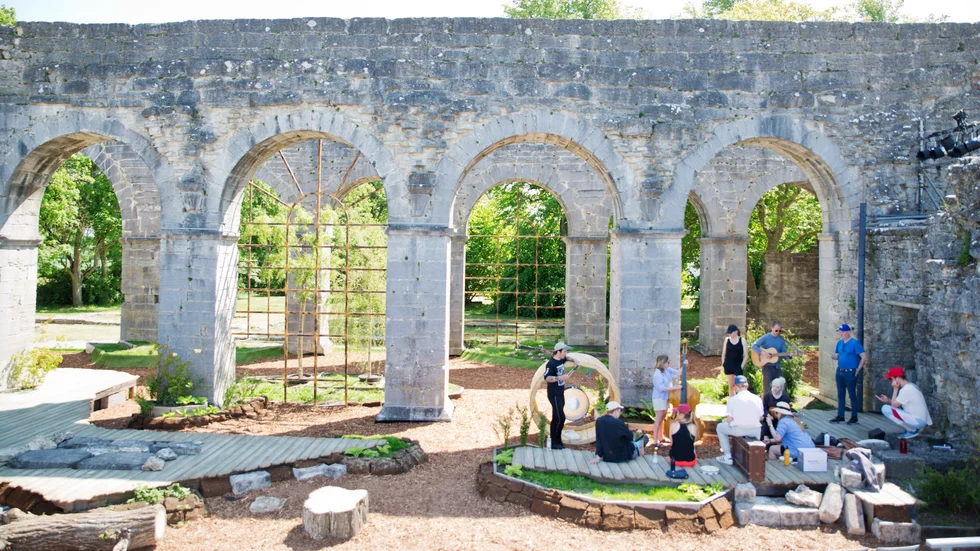 Klosterruinen i Roma iscensätts med täckbark, stockar, stenar och rabatter för att bli den djupa Ardennerskogen där Shakespears karaktärer tar sin tillflykt.
