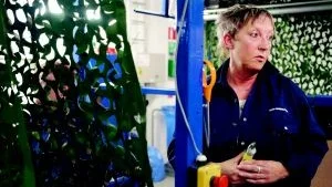 Nätsvets. Berit Wiregård sysslar egentligen mest med att sy kamouflagenät, men här visar hon hur det går till när kamouflaget av plast svetsas ihop med själva nätet. Den lilla manincken hon har i handen är använder hon för att svetsa ihop de bitar som maskinen missar. Foto: Anna Persdotter