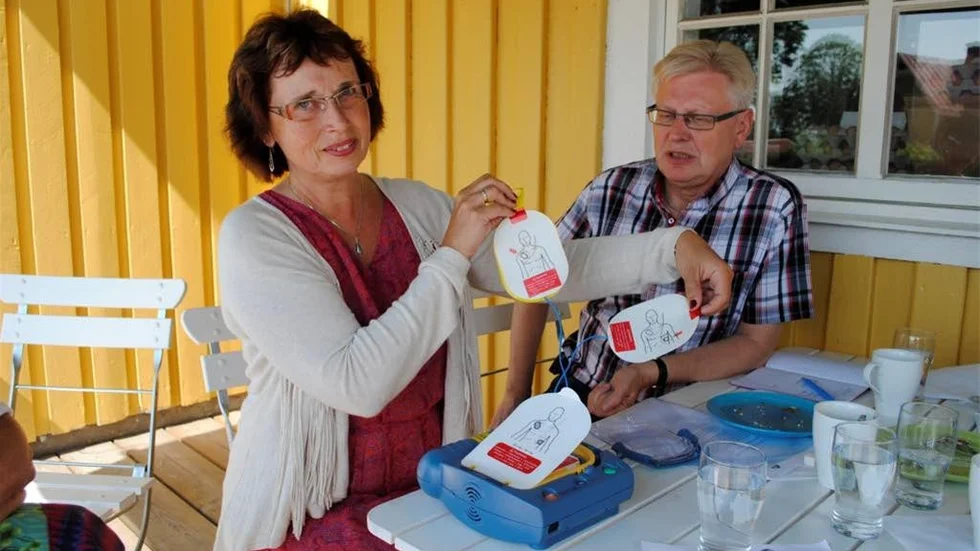 Gudrun Brunegård (KD) visar hur en hjärtstartare fungerar. Vid hennes sida Anders Andersson (KD). De tycker att det är bra att många vet hur en hjärtstartare fungerar, men eftersöker bättre vårdförutsättningar i norra kommundelen.