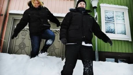 Tina Revelj, till vänster, och Martina Andersson från hemtjänsten tvingas forcera meterhöga snövallar på Gösta Bernhards gata i centrala Västervik.