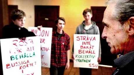 PROTEST. Tekniska nämndens ordförande Kjell Skalberg (c) möttes av demonstranter från SSU när kommunfullmäktige i går skulle besluta om inskränkningar i bussiga kortet. Ungdomarna i bild heter Richard Gyllensten, Adriaan van Tour och Anton Linnerhed.