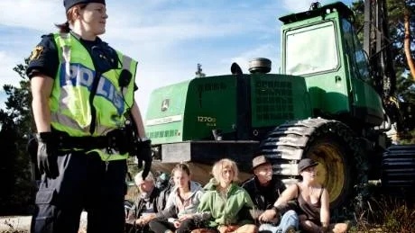 Bildade kedja. Några av aktivisterna försökte stoppa en skogsmaskin genom att sätta sig framför den. "Vi har så svag miljölagstiftning. Det finns ingenting som kan stoppa mineralbolagen", säger Wolfgang Brunner, som var en av demonstranterna. En stund senare bars de bort från maskinen. Foto: Joel Nilsson