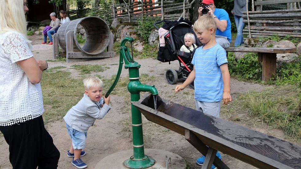 Barnen leker i den tidsenliga naturlekplatsen, pumpa vatten är populär.