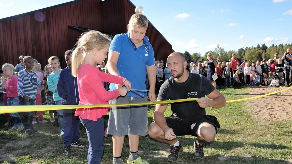 Eleverna Tuwa Tildemyr och Johan Andersson fick hjälp av vaktmästaren vid Bäckskolan, Anton Frid, när bandet högtidligen skulle klippas.