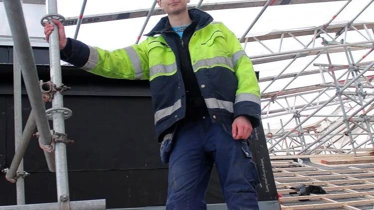 En plåtslagare får inte vara rädd för höjder, påtalar Gustav Mattsson från sin plats uppe på taket till huset Barnhemsgatan där 18-åringen gör sin praktik.