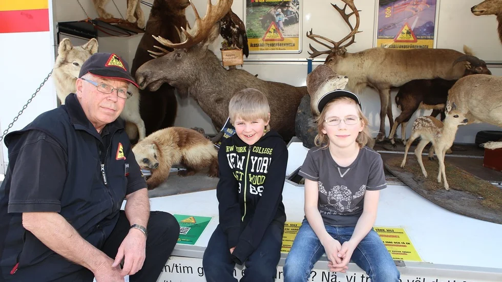 Åke Johansson med barnbarnen Viktor och Jakob Karlsson framför alla uppstoppade djur.