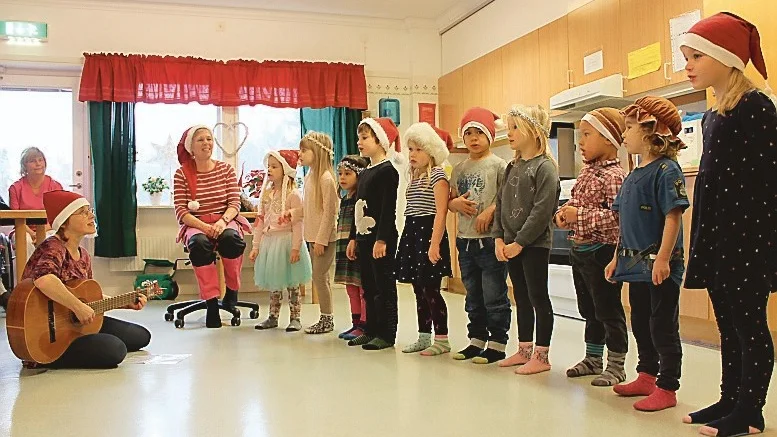 En del av barnen från förskolan Hanna i Gamleby. Lizabet Moberg kompar på gitarr, Birgitta Björkman hjälper till med sången. Barnen heter Tindra Björklund, Moa Falkman, Felicia Bech, Joshua Svefors, Nellie Augustsson, Alexandro Nyberg, Tyra Steensrum, Leonard Nyberg och Tuva Sleman. Foto: Lena