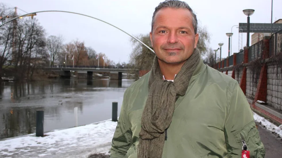 Drömmar.  Michael Gharib vill göra en flickas drömresa möjlig. Bakom honom syns Linköpings kända konstverk, Drömmarnas båge.
