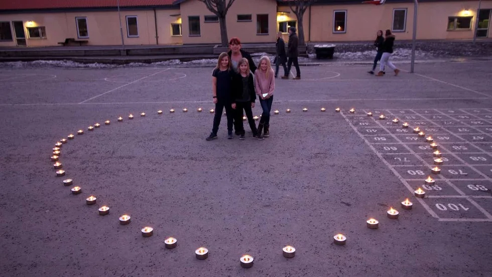 Mamma Camilla håller om Ebba Kronstrand, dottern Alva och Elise Nåbo på Vikingstadsskolans skolgård.