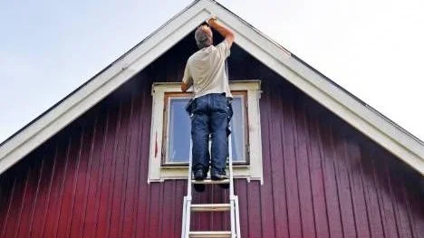 GRÄSKÖ 2010-08-08 Man står på en stege och målar om sitt hus.
Foto Hasse Holmberg / SCANPIX Kod 96