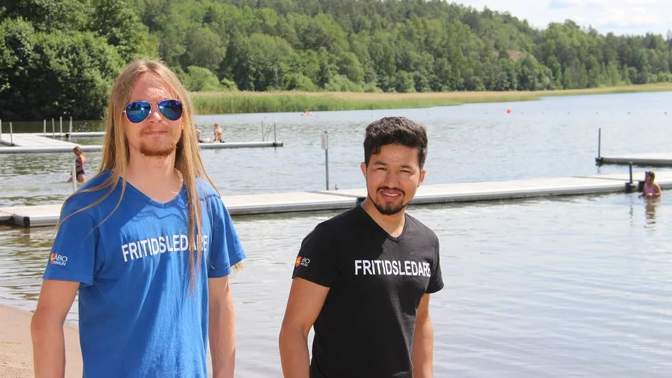 De kommunala bryggorna är inringade av säkerhetsskäl. Några badsugna gäster testar vattnet bakom verksamhetsansvarige Patric Öberg och fritidsledaren Bashir Atai.