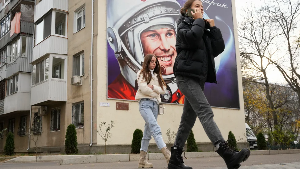 Två kvinnor passerar en anslagstavla prydd av den första kosmonauten Jurij Gagarin, i Transnistriens största stad Tiraspol. Bilden är tagen i november 2021. Arkivbild.