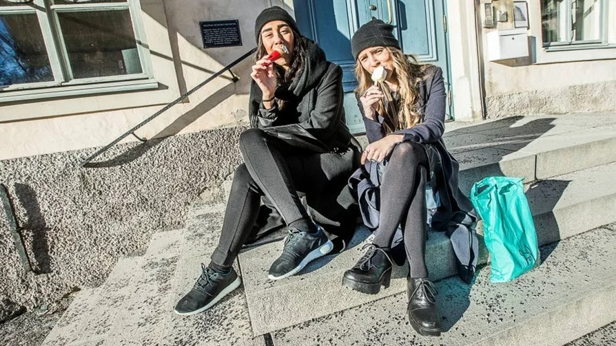 Vårkänslor. Emma Woldemeskel och Anna Waxin har valt en solig favoritplats i lä, där de äter årets första glass.