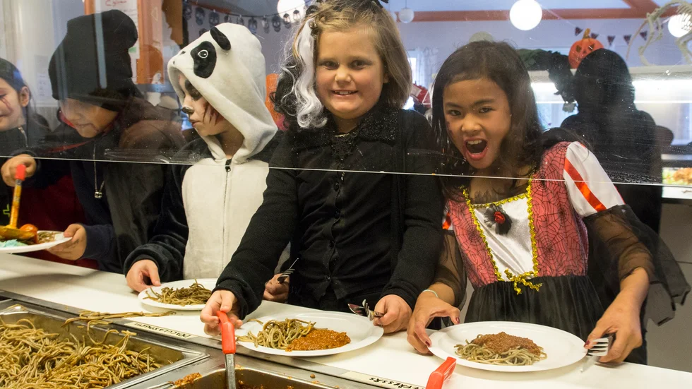 Elin Florestig och Airish Ynzon hugger in på Draculaspagetti med zombiefärssås under Västra skolans halloweenlunch.