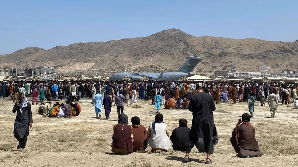 Hundratals människor trängs i närheten av ett amerikanskt militärflygplan på Kabuls flygplats tidigare i veckan.