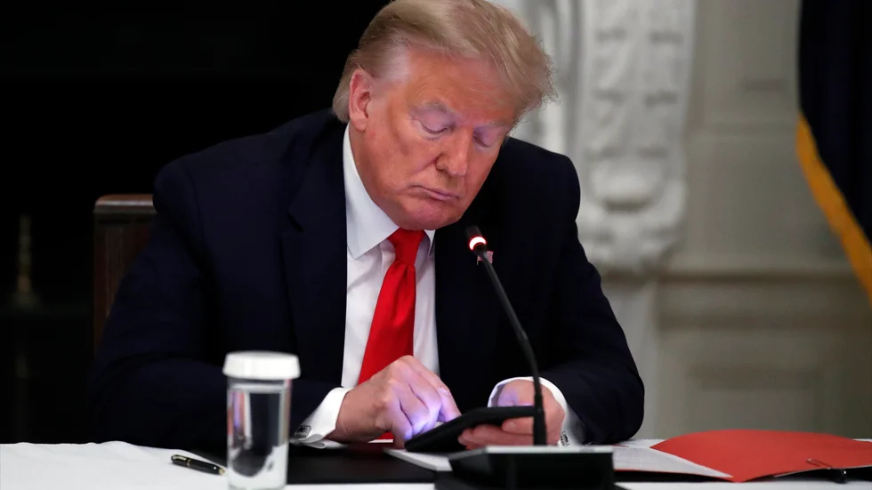 Dåvarande presidenten Donald Trump med sin telefon under ett möte i Vita huset i juni 2020.