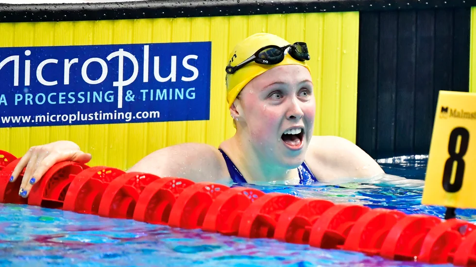Emelie Fast reagerar med förvåning när hon inser att hon är OS-klar efter att ha slagit personligt rekord med drygt två sekunder på 100 meter bröstsim i EM.