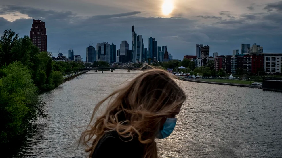 En kvinna med munskydd på en bro över floden Main i Frankfurt. Bilden är från i torsdags.