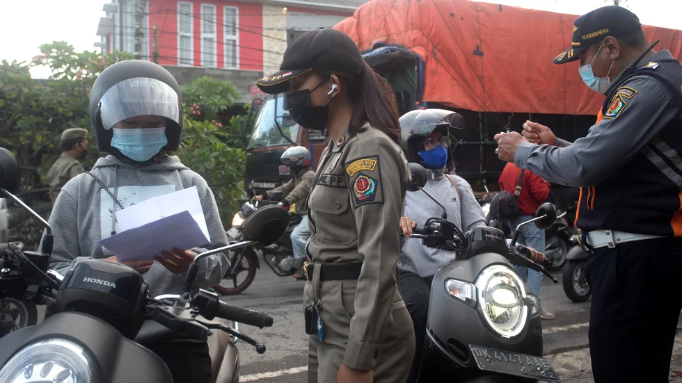 Säkerhetspersonal kontrollerar trafikanter på Bali, Indonesien.