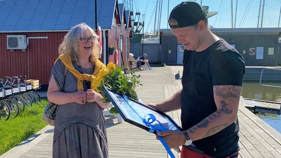 Här överraskas Johan Wolpher, VD för Apelago Group med utmärkelsen årets nyföretagare i Trosa. Birgit Båvner från Nyföretagarcentrum Östra Sörmland räcker över diplomet på bryggan vid Trosa Gästhamn.