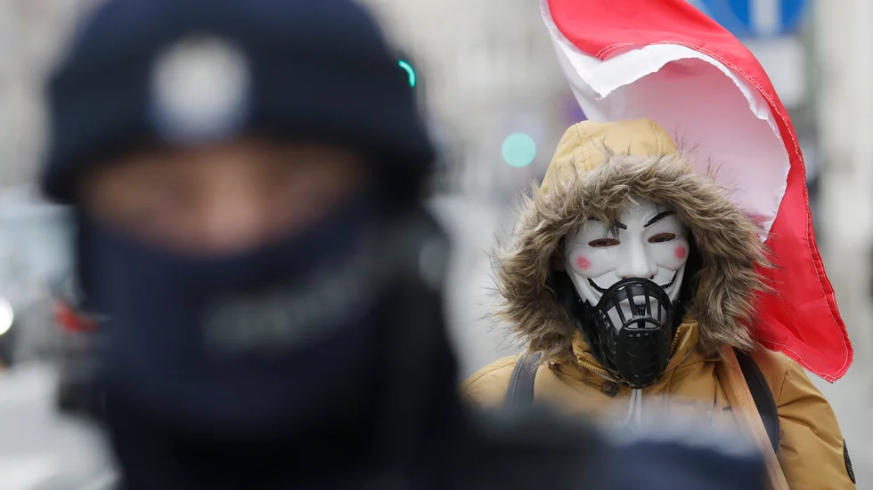En man protesterar mot restriktionerna i Polen. Arkivbild.