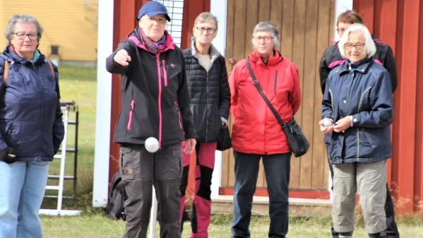 . Inga Andersson längst till höger, visar intresserade hur boulespel går till. 