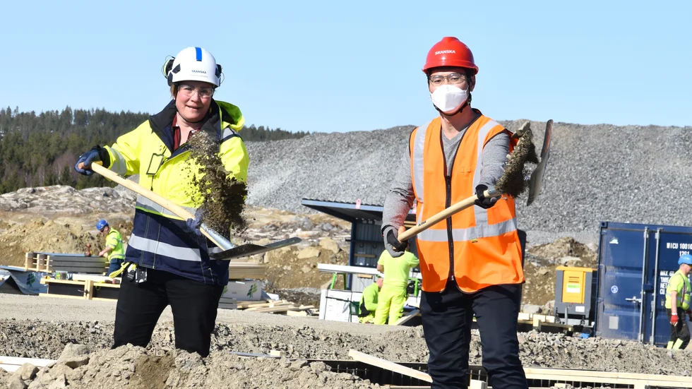 Yun Lee, fabrikschef, Dongjin Sweden (t h), och Linda Hillergren, projektchef, Skanska, tar ett icke formaliserat första spadtag till Dongjins nya fabrik på Skellefteå Site East.