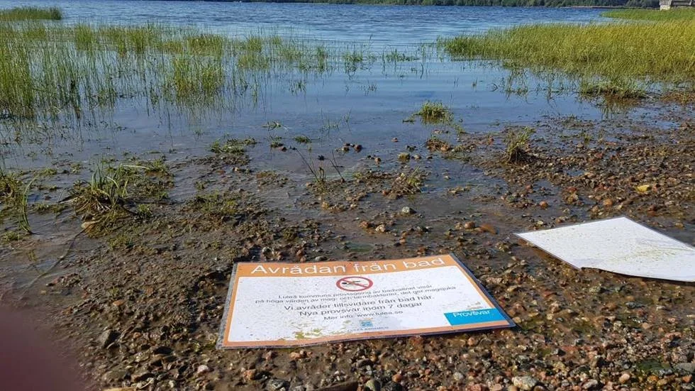 Badet vid Tunastrand har otjänligt vatten och kommunen har satt upp skyltar. Vid torsdagen hade dock några skyltar fallit ner och låg i geggan vid strandkanten.