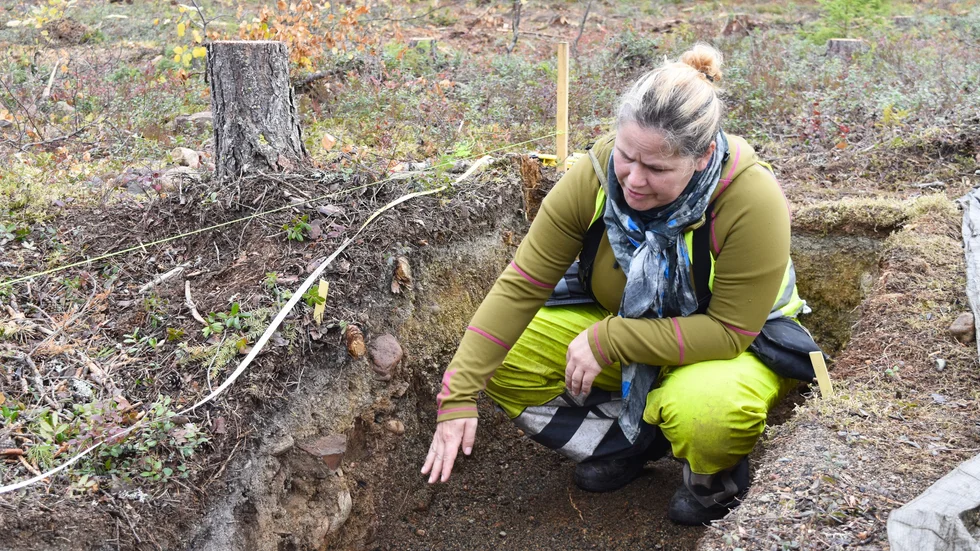 Therese Hällqvist visar en kokgrop. Sanden är något rosafärgad vilket betyder att den utsatts för värme.
