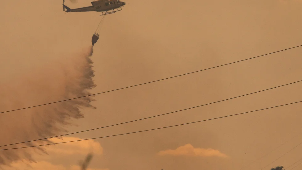 Brandbekämpningsflyg deltar i släckningsarbetet i den svårtillgängliga terrängen.
